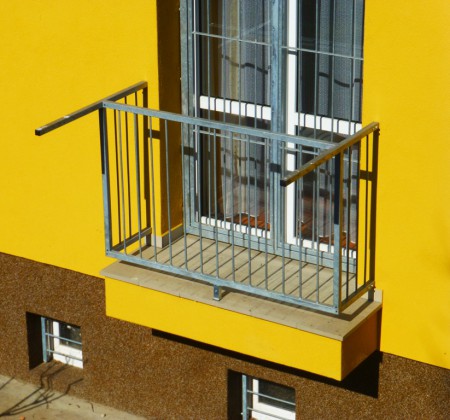 Detail balkónového zábradlí a mříže.